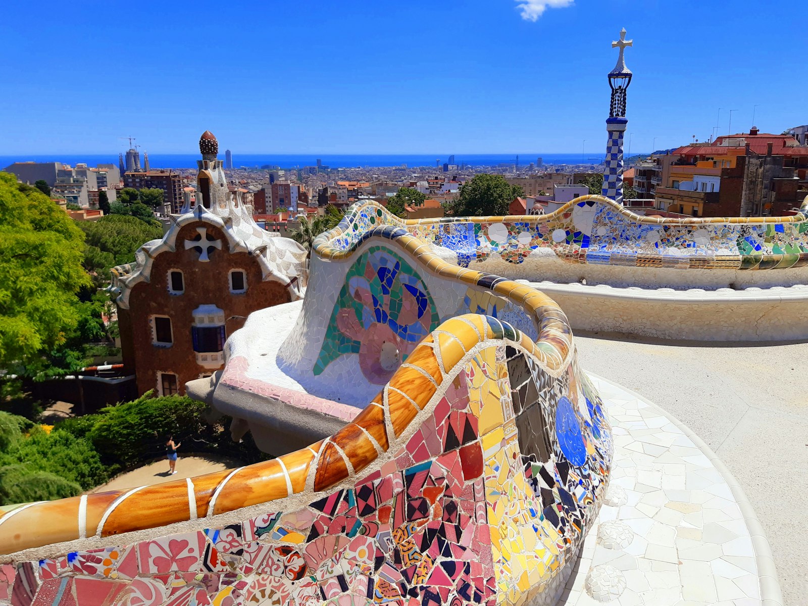 The mosaic serpentine bench at Park Güell with Barcelona and the sea beyond